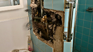 Exposed shower valve in a 1960s bathroom.
